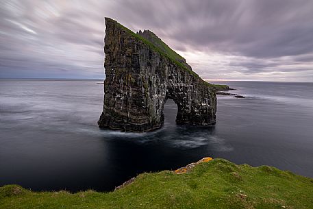 Drangarnir is the collective name of two sea stacks, which are called Stóri Drangur (large rock) and Lítli Drangur (small rock) respectively, and are located next to each other between the islands of Vágar and Tindhólmur, Sørvágsfjørður Fjord near Sørvágur, Faeroe islands, Denmark Drangarnir is the collective name of two sea stacks, which are called Stóri Drangur (large rock) and Lítli Drangur (small rock) respectively, and are located next to each other between the islands of Vágar and Tindhólmur, Sørvágsfjørður Fjord near Sørvágur, Faeroe islands, Denmark